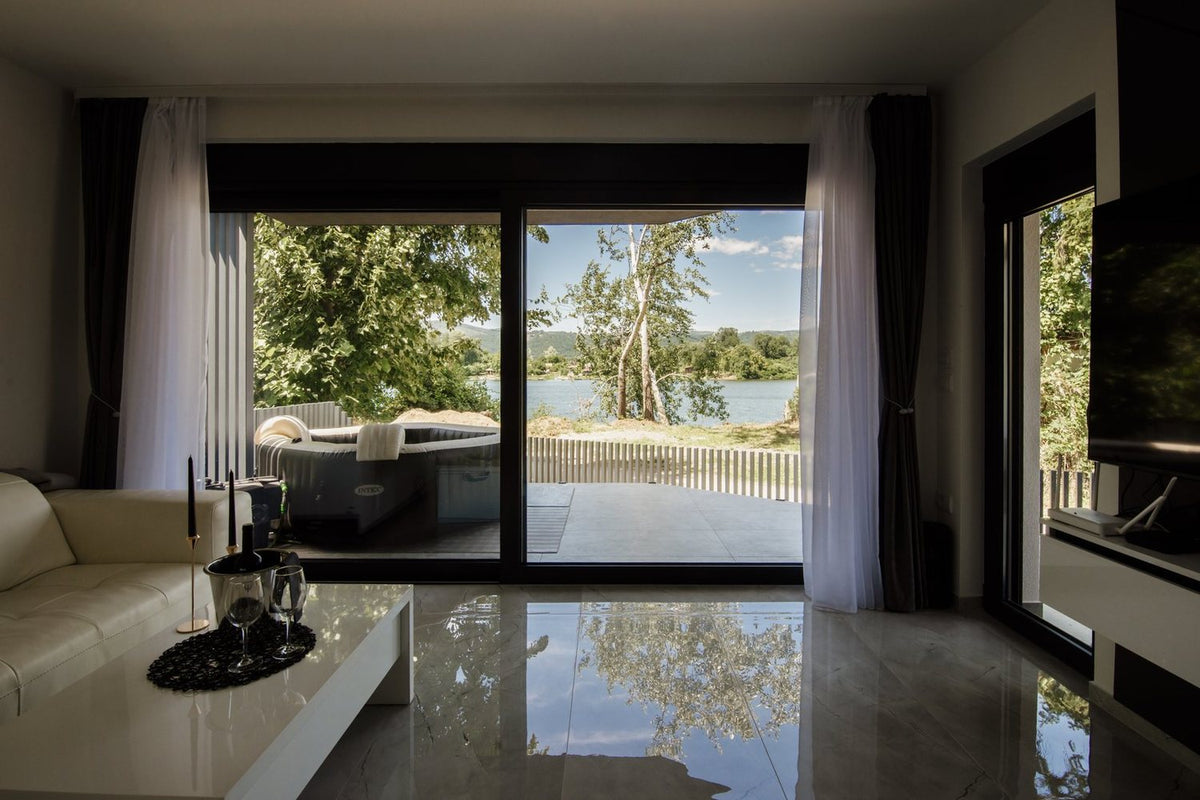 Bright living room with floor-to-ceiling windows overlooking a lake
