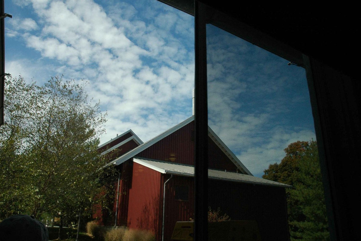 Window film applied to a house window reflecting the sky
