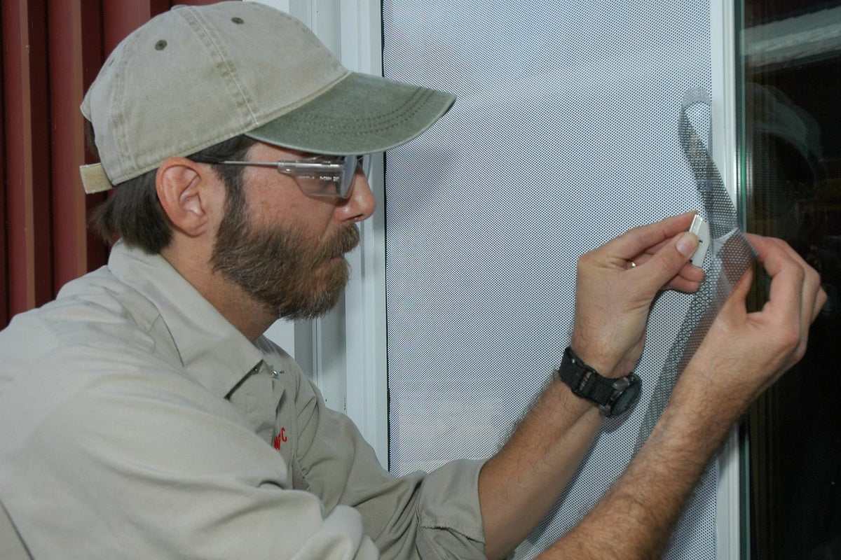 Man applying film to a window