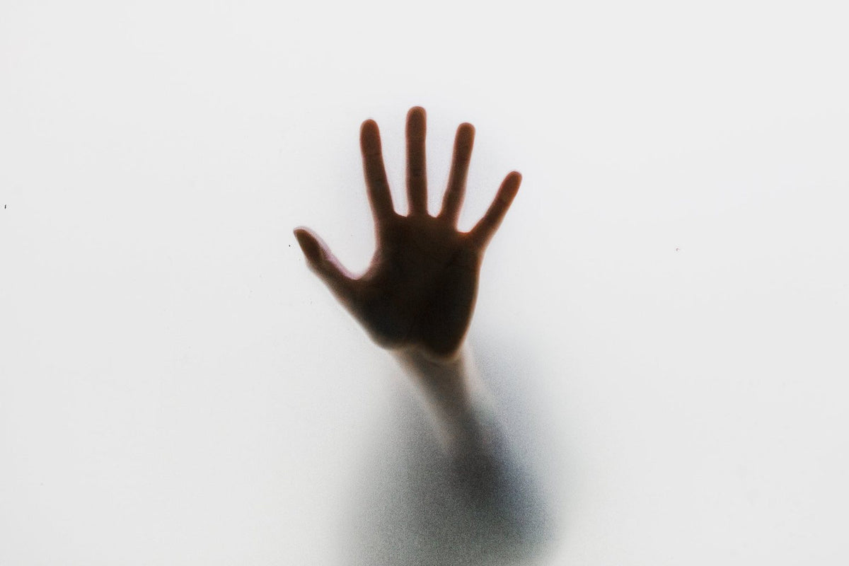 Hand pressed against frosted glass