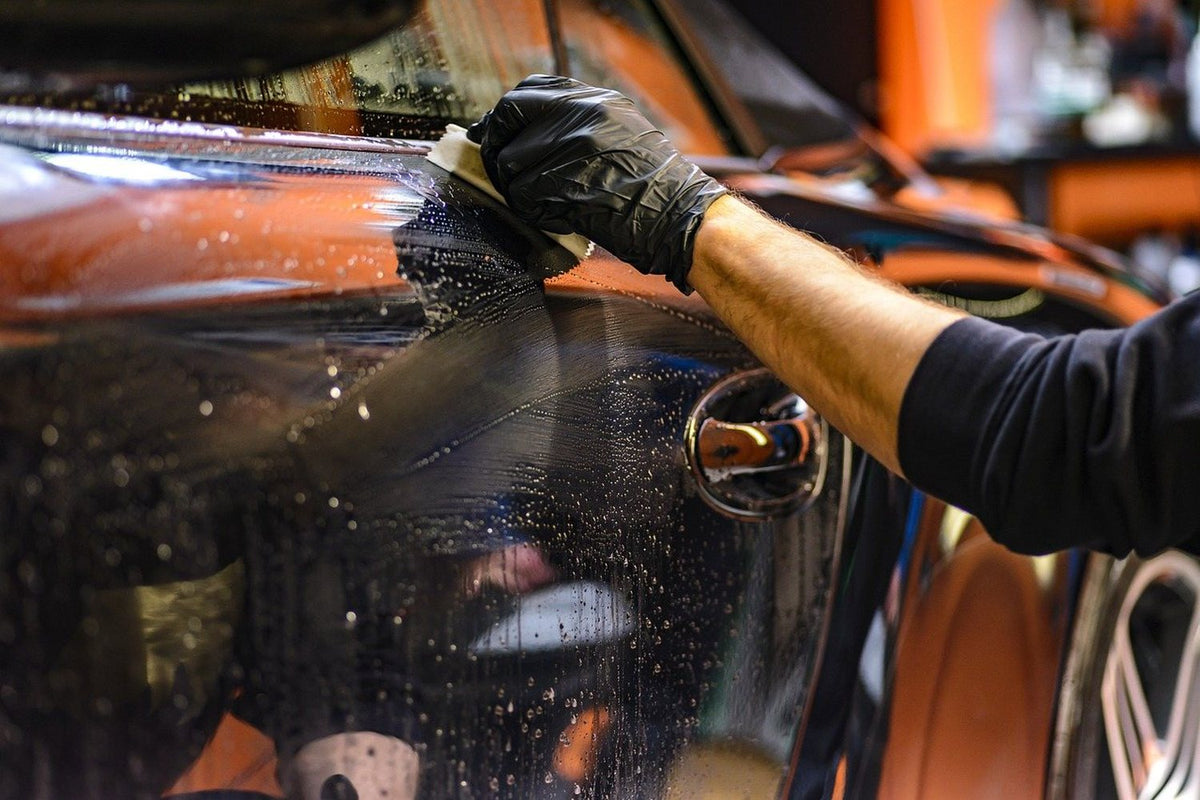 Detailer finishing the paint on a car